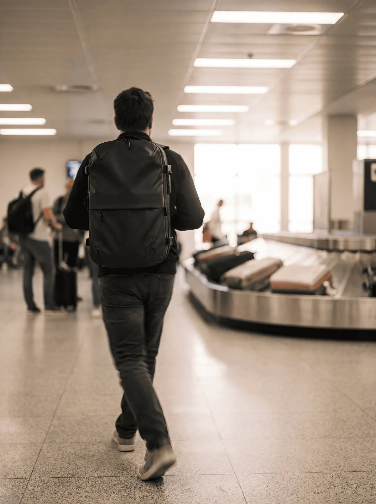 A traveller walks past an airport baggage carousel with the ProPack on their back